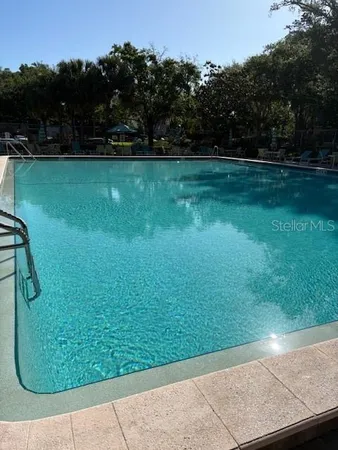 a view of a swimming pool with a table and chairs under an umbrella