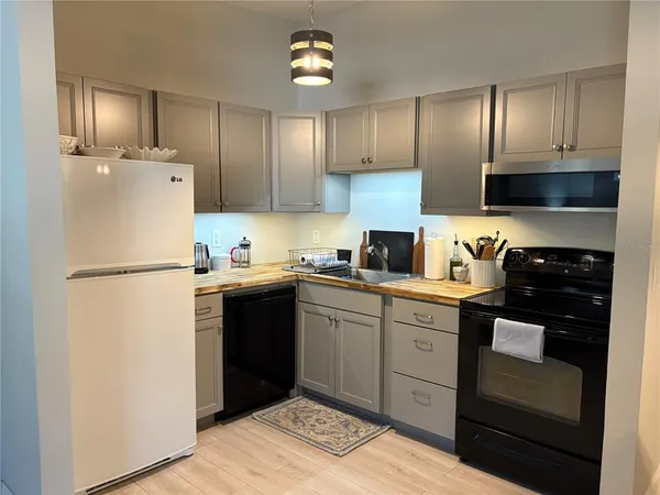 a kitchen with a refrigerator sink and cabinets