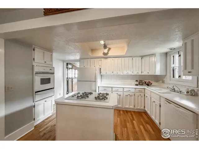 a kitchen with stainless steel appliances kitchen island granite countertop a sink stove and refrigerator
