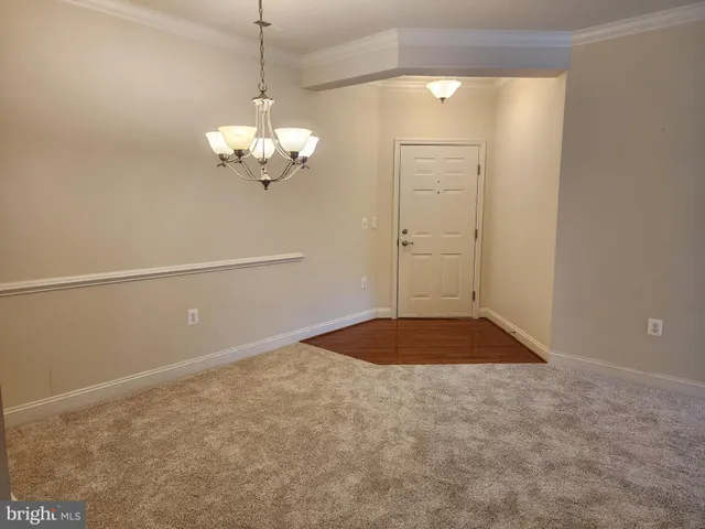 a view of an empty room with a chandelier fan