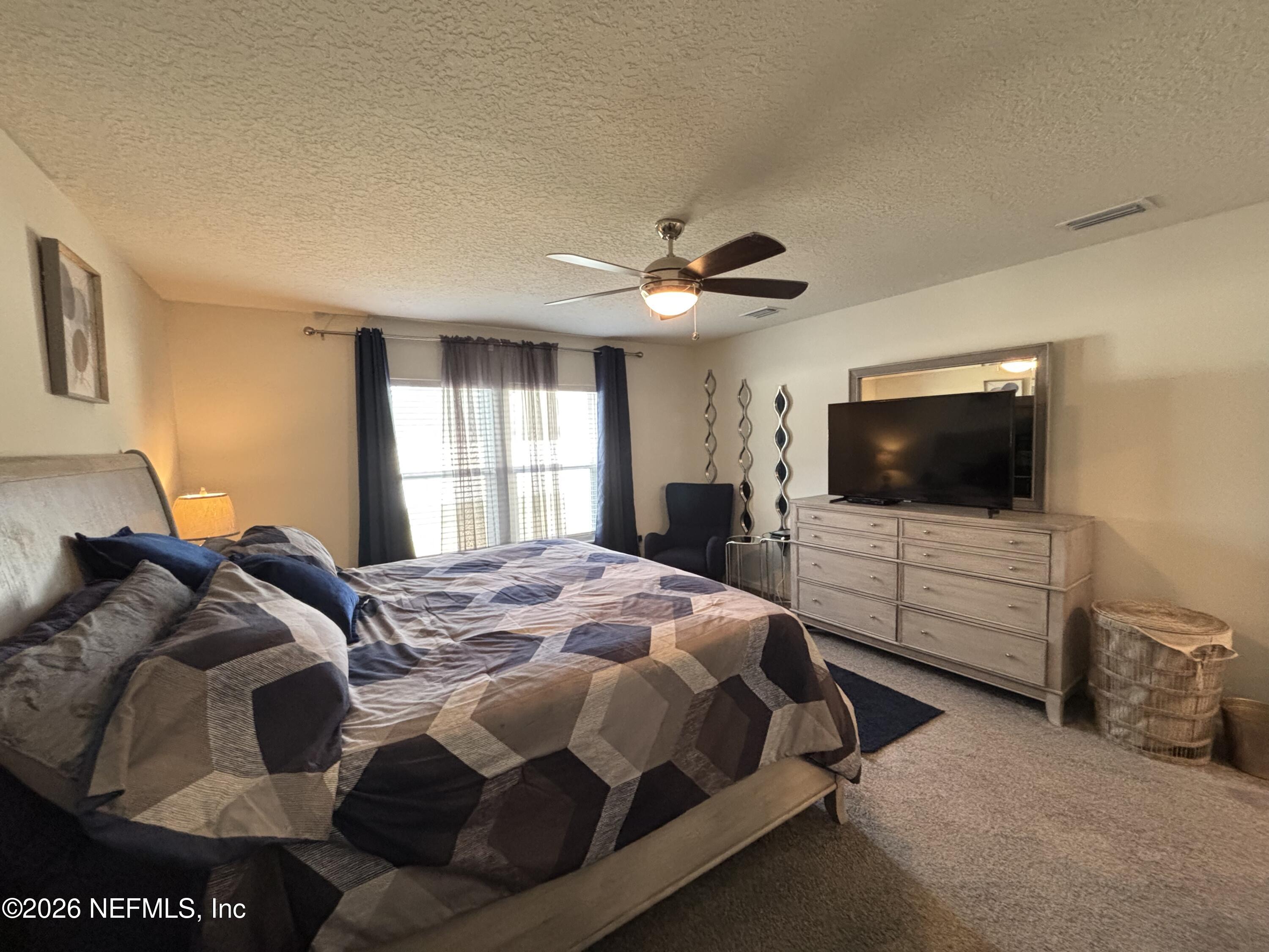 8280 Fouraker Forest Road Jacksonville, FL 32221 - Photo 17 of 25 a bedroom with a bed and a flat screen tv