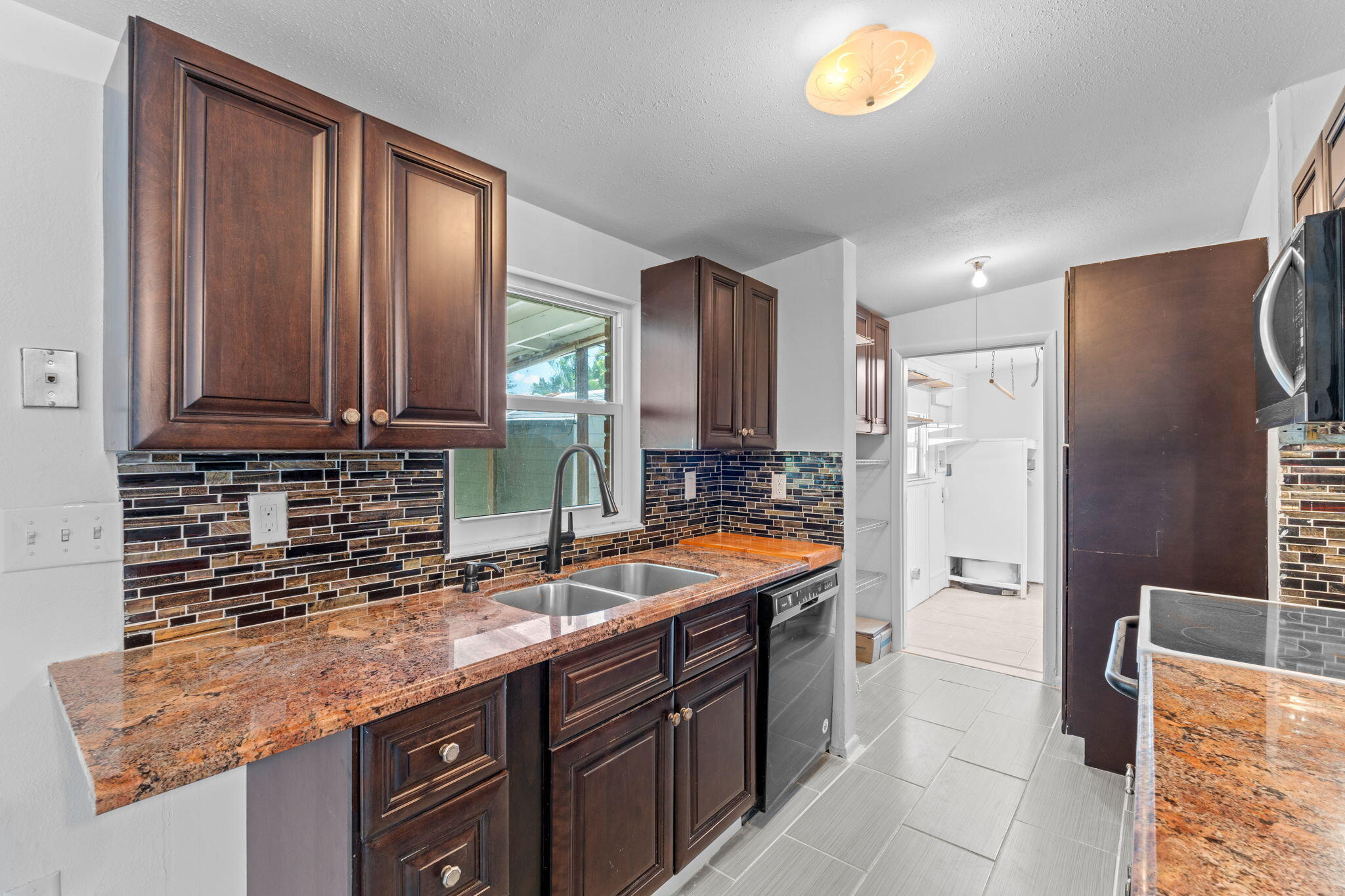 3852 Catalina Road Palm Beach Gardens, FL 33410 - Photo 19 of 48 a kitchen with stainless steel appliances granite countertop a sink stove and refrigerator