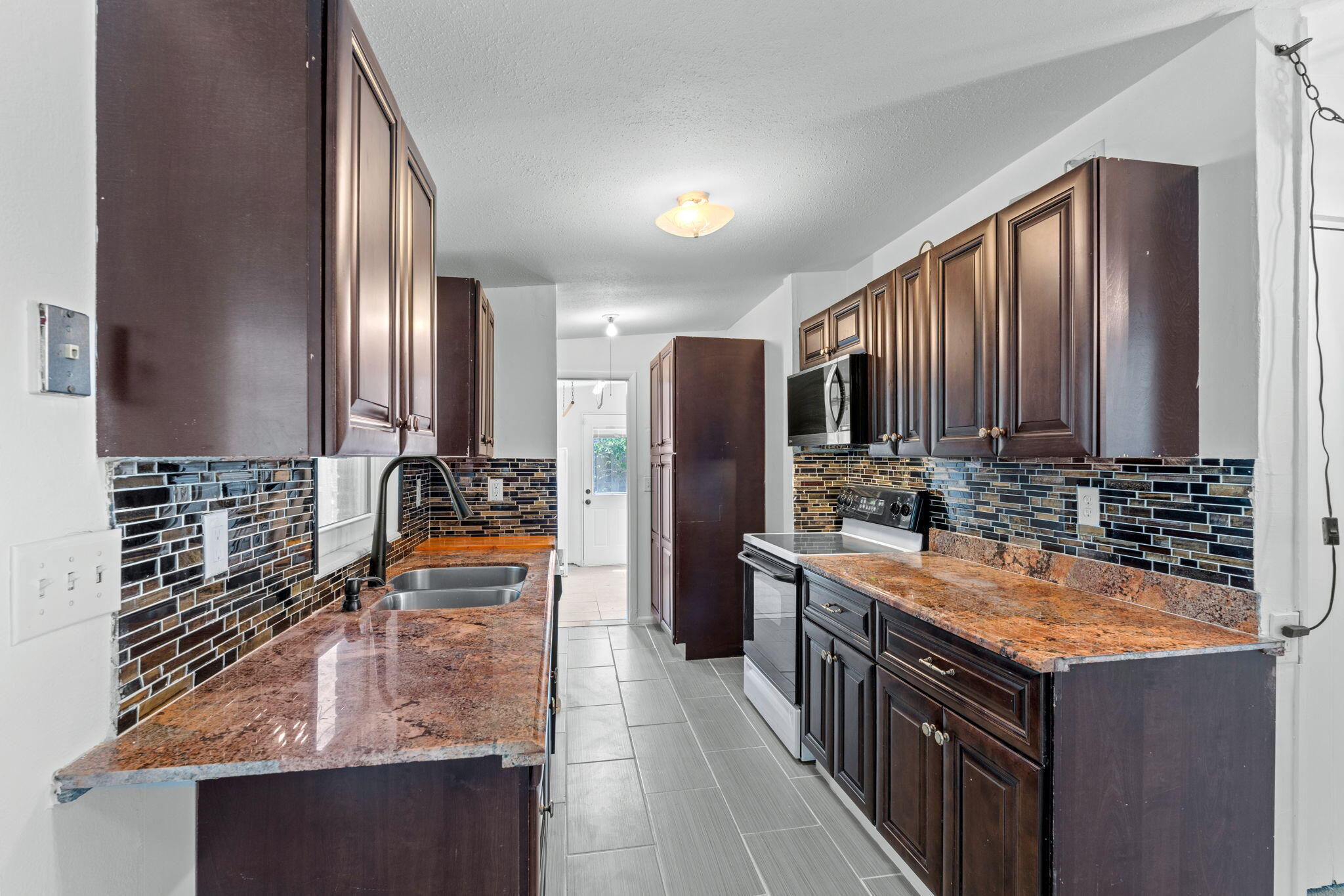 3852 Catalina Road Palm Beach Gardens, FL 33410 - Photo 21 of 48 a kitchen with stainless steel appliances granite countertop a sink stove and refrigerator
