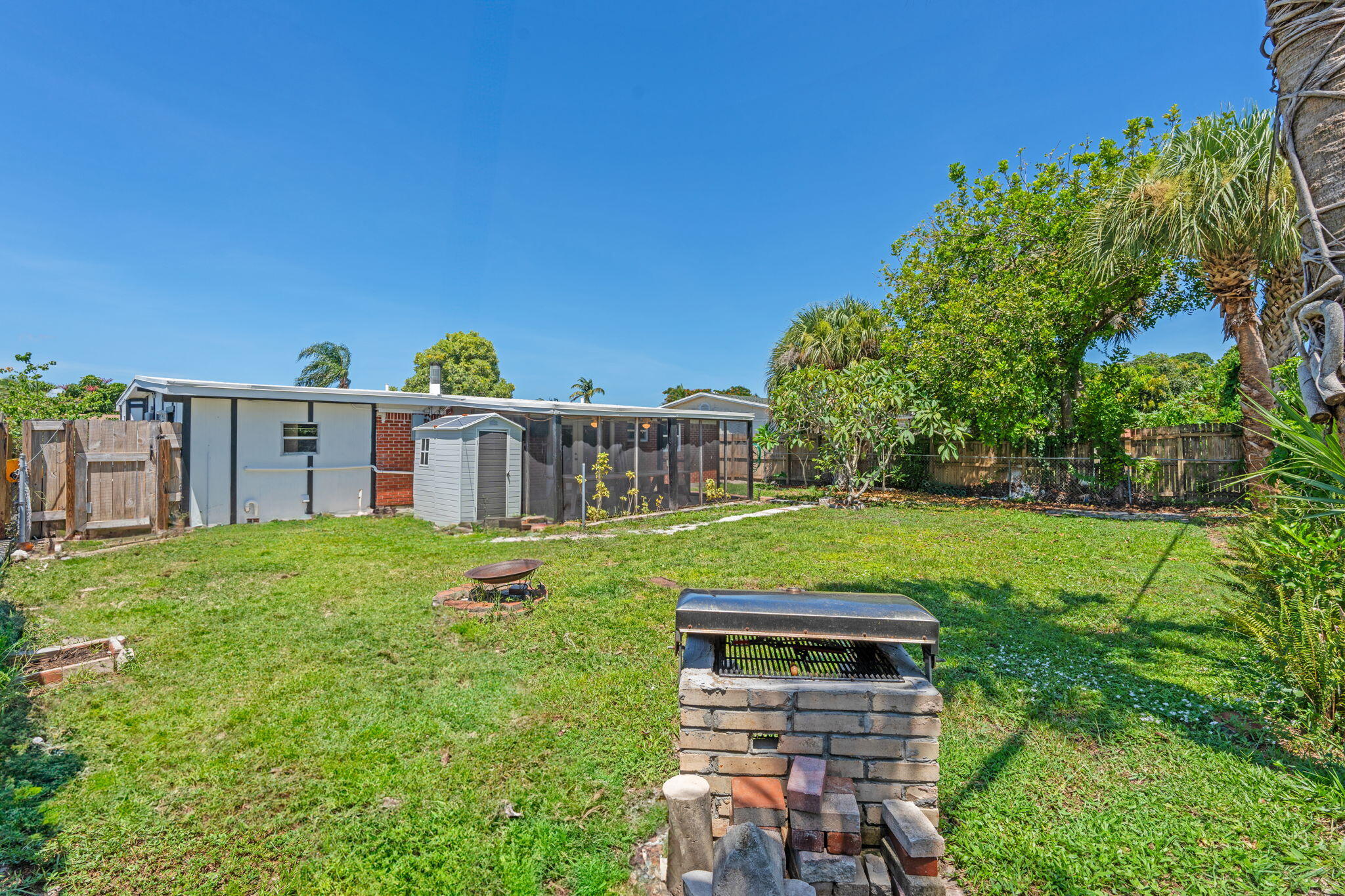 3852 Catalina Road Palm Beach Gardens, FL 33410 - Photo 25 of 48 a backyard of a house with table and chairs