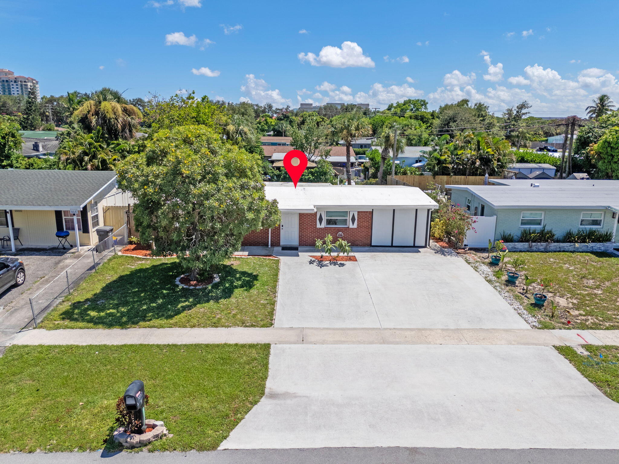 3852 Catalina Road Palm Beach Gardens, FL 33410 - Photo 31 of 48 a front view of a house with a yard and a garden