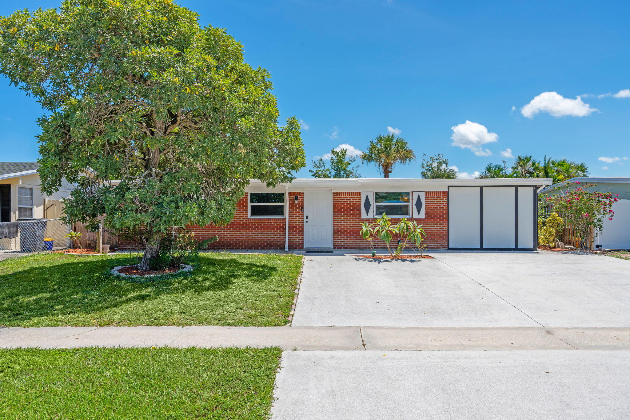 3852 Catalina Road Palm Beach Gardens, FL 33410 - Photo 4 of 48 front view of a house with a yard