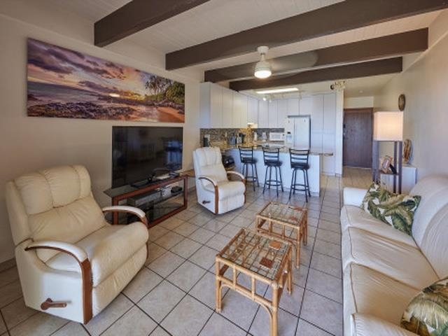 2075 South Kihei Road, Unit 114 Kihei, HI 96753 - Photo 3 of 14 a living room with furniture a flat screen tv and kitchen view