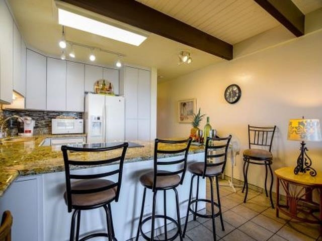 2075 South Kihei Road, Unit 114 Kihei, HI 96753 - Photo 6 of 14 a view of a kitchen with furniture and a table