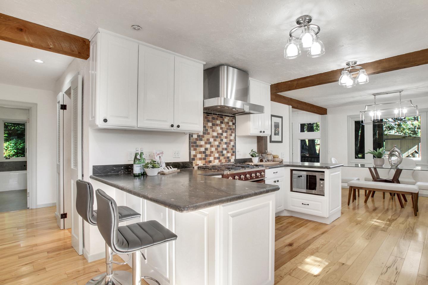 165 Old Ranch Road Woodside, CA 94062 - Photo 11 of 60 a kitchen with kitchen island granite countertop a stove cabinets and wooden floor