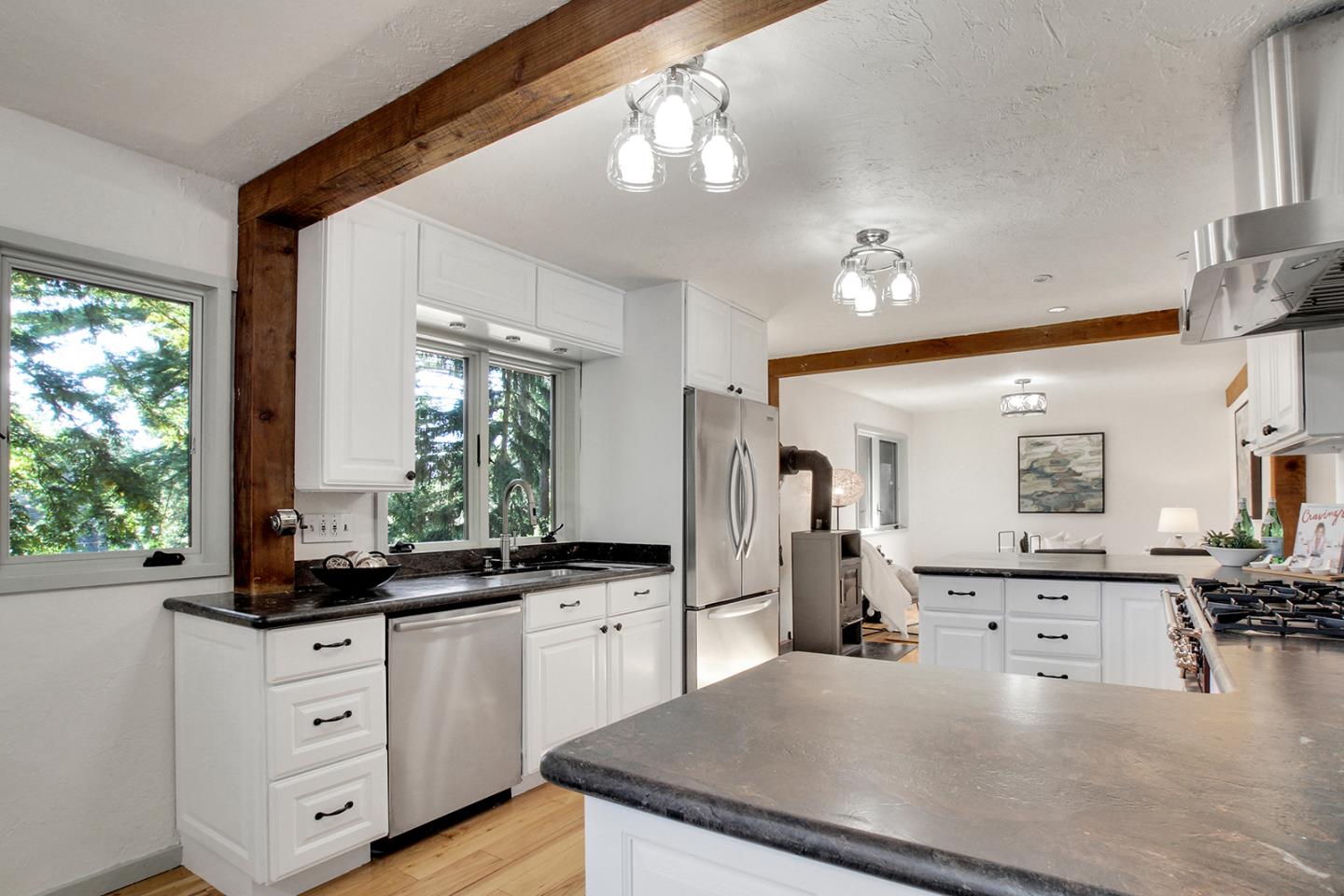165 Old Ranch Road Woodside, CA 94062 - Photo 9 of 60 a large kitchen with kitchen island a counter space a sink a window and stainless steel appliances