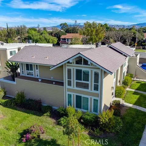 a aerial view of a house with a yard and a large tree