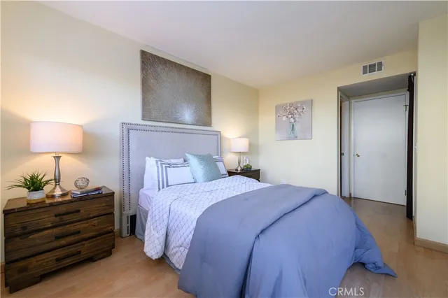 a bedroom with a bed and a lamp on the dresser