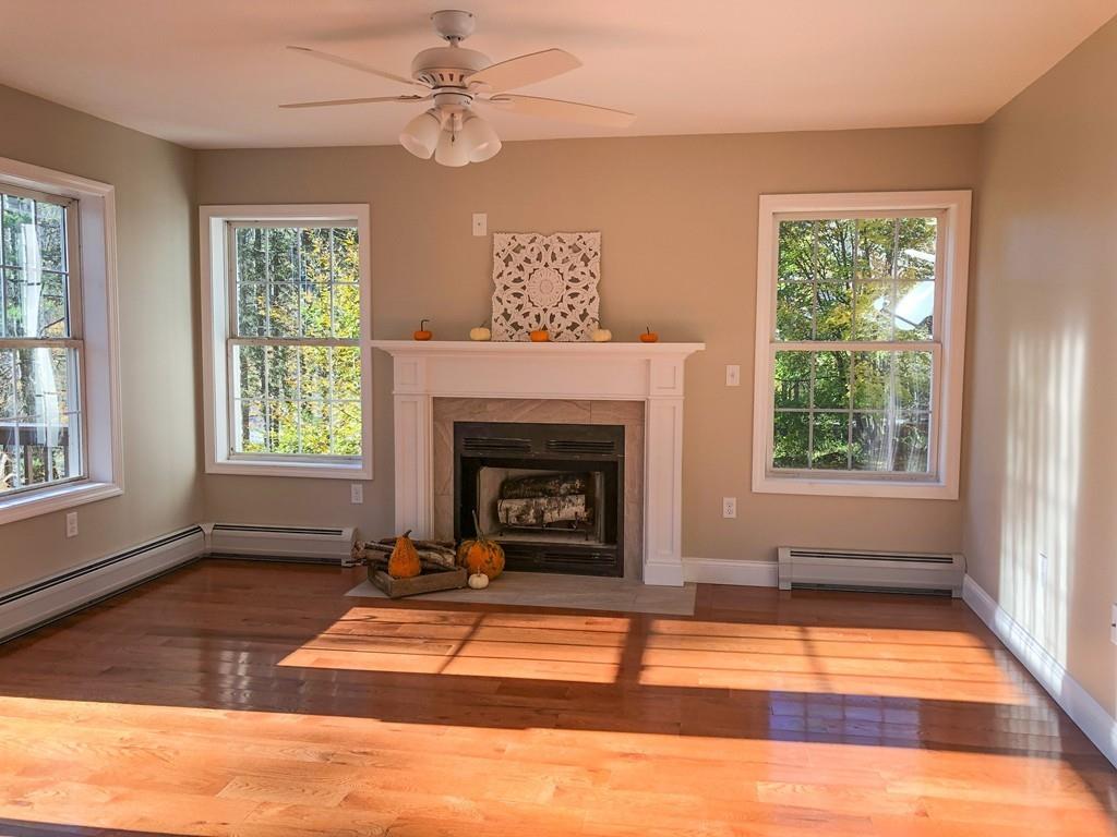 499 Jacksonville Road Colrain, MA 01340 - Photo 19 of 30 a living room with a fireplace windows and a rug