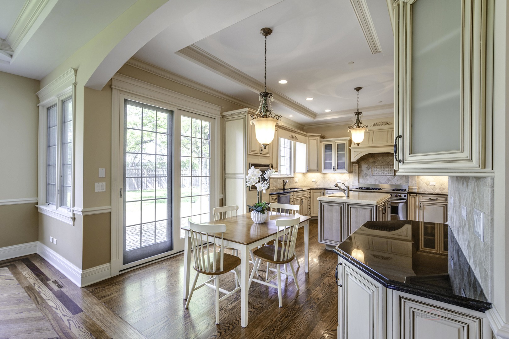 214 Linden Road Northbrook, IL 60062 - Photo 16 of 56 a kitchen with stainless steel appliances granite countertop a stove top oven a dining table and chairs with wooden floor