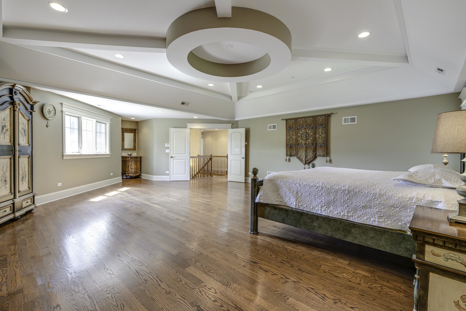 214 Linden Road Northbrook, IL 60062 - Photo 28 of 56 a spacious bedroom with a bed a dresser and a chandelier