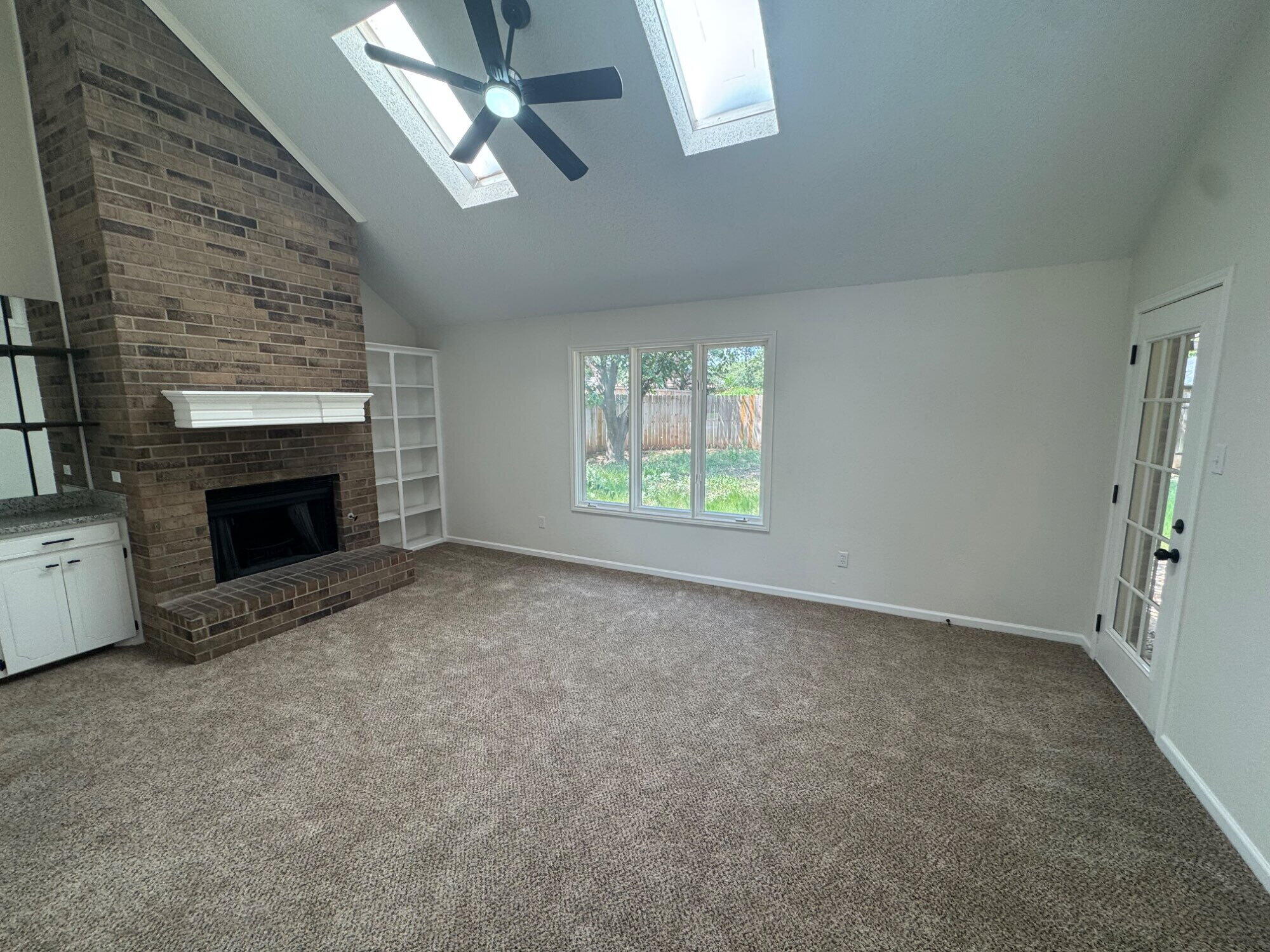 5510 87th Street Lubbock, TX 79424 - Photo 2 of 13 an empty room with windows and fireplace