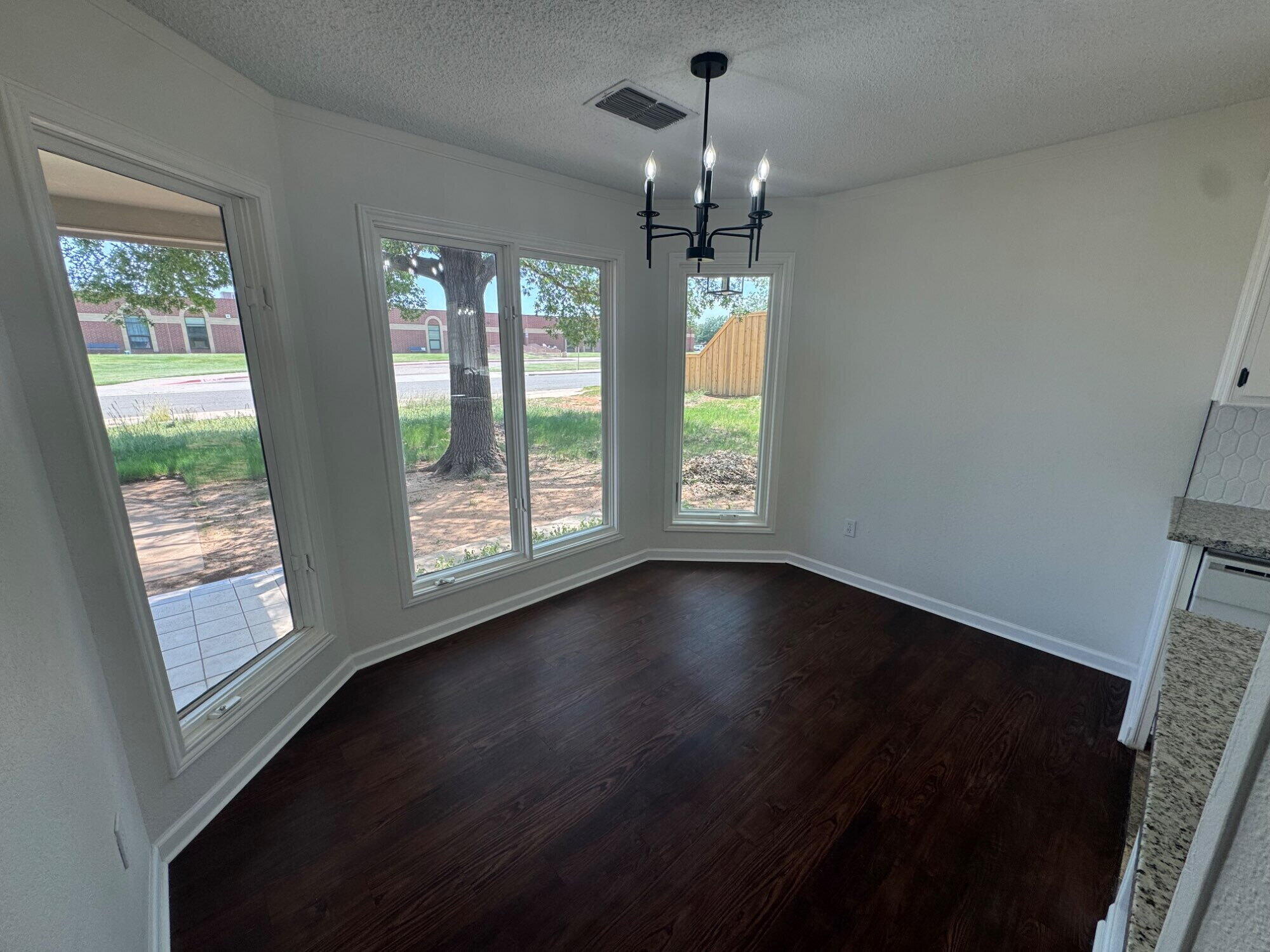 5510 87th Street Lubbock, TX 79424 - Photo 3 of 13 a view of an empty room with wooden floor and a window