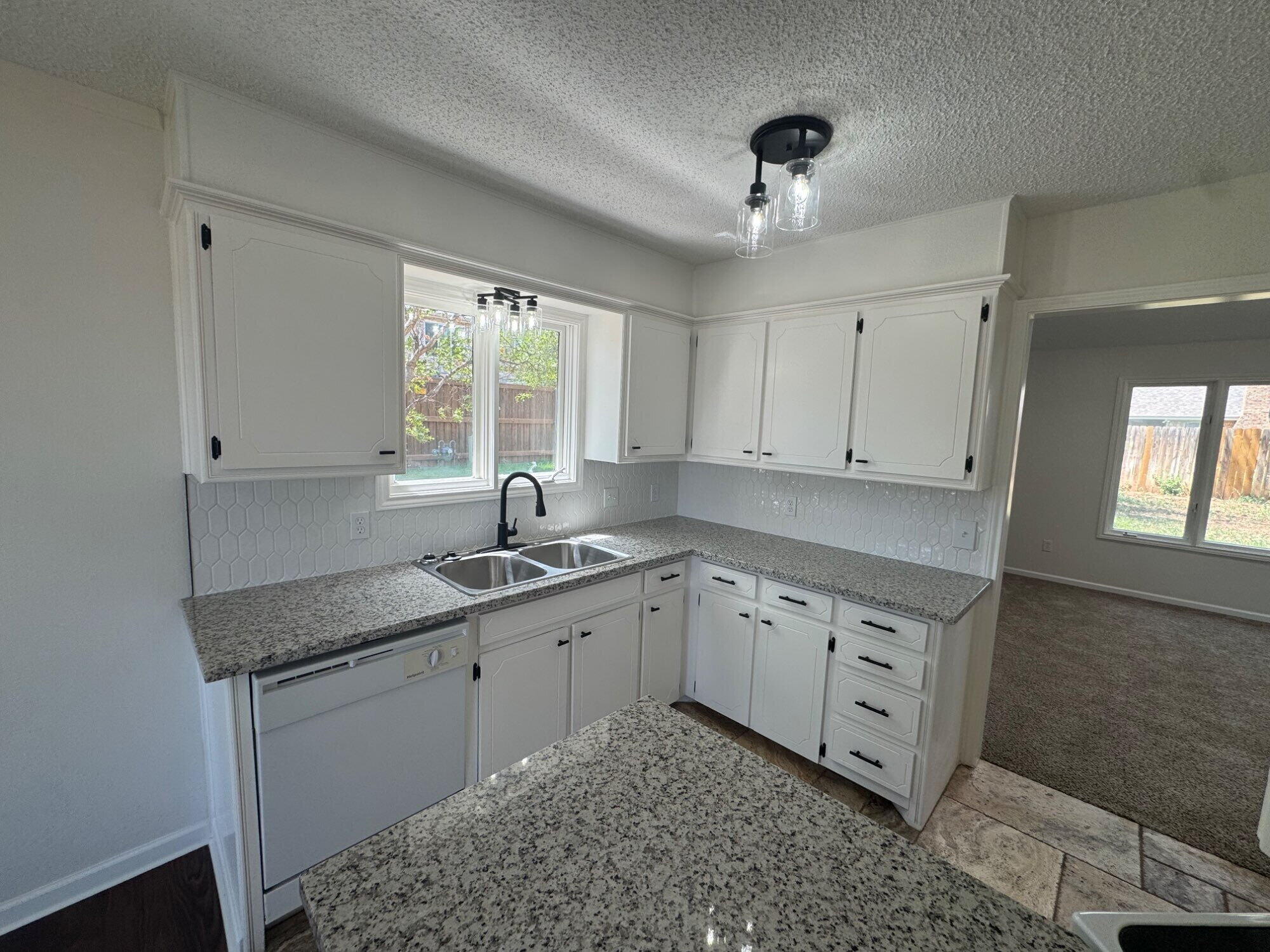5510 87th Street Lubbock, TX 79424 - Photo 4 of 13 a kitchen with granite countertop a sink cabinets window and stainless steel appliances