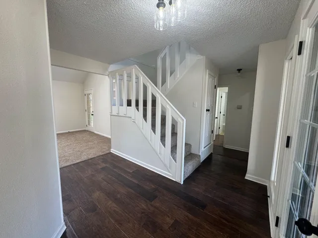 a view of a hallway with wooden floor and staircase