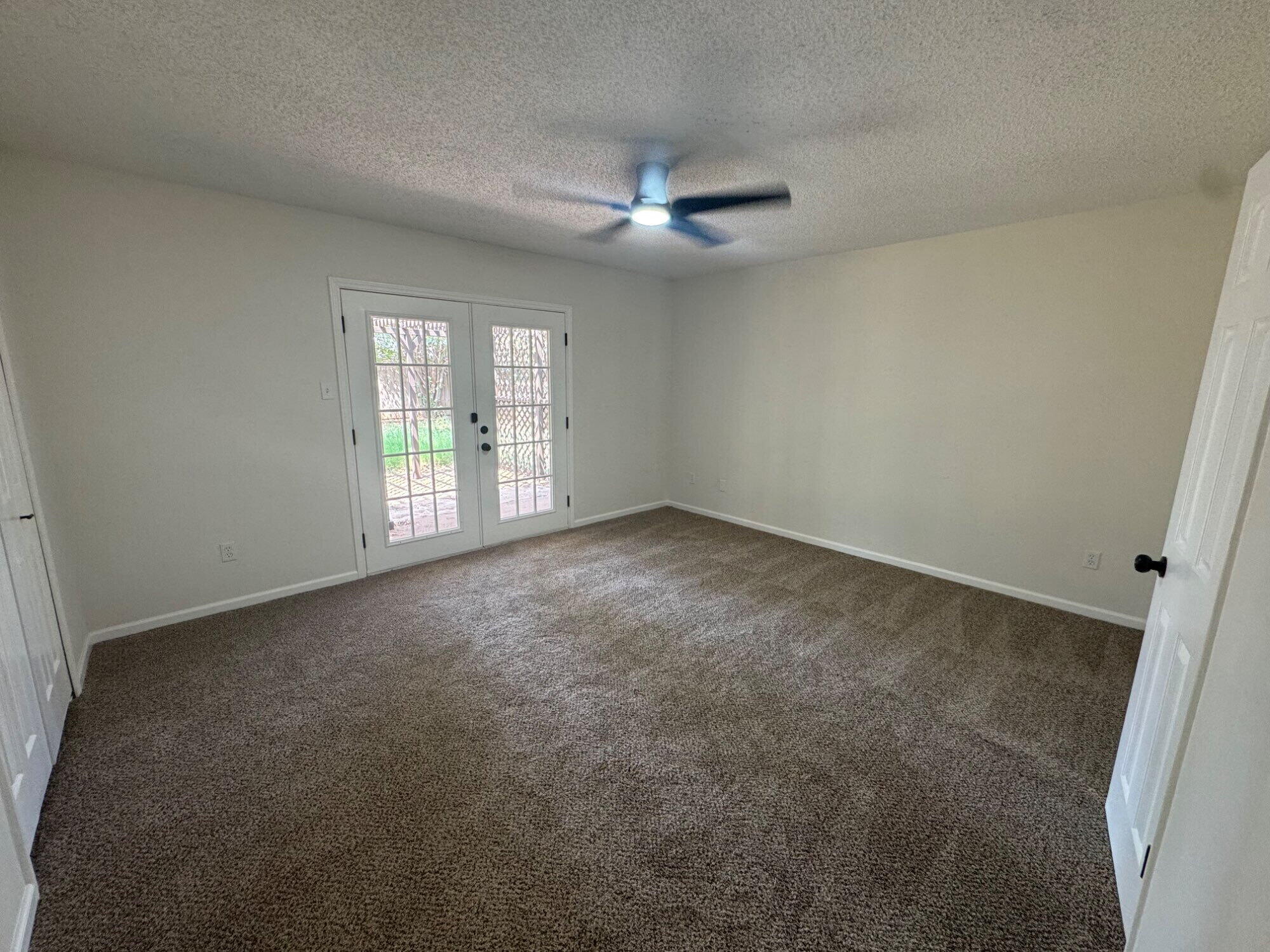 5510 87th Street Lubbock, TX 79424 - Photo 7 of 13 an empty room with windows and ceiling fan
