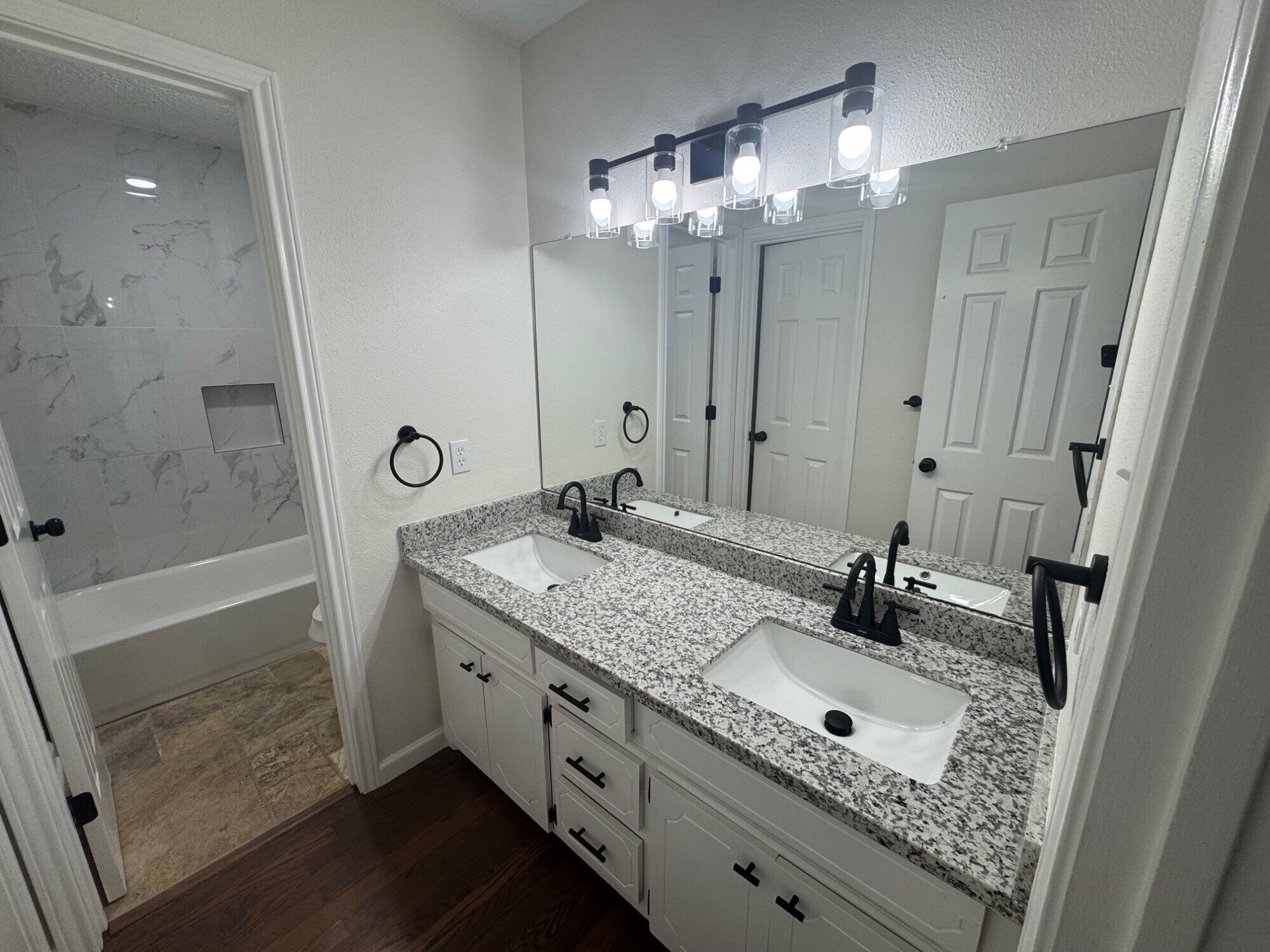 5510 87th Street Lubbock, TX 79424 - Photo 8 of 13 a bathroom with a sink double vanity granite tub shower and mirror