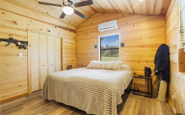 a bedroom with a bed and wooden floor