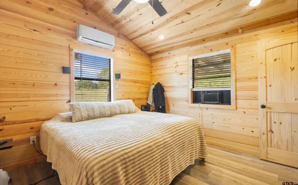 a bedroom with a bed and wooden floor