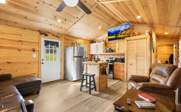 a view of a kitchen with furniture and wooden floor