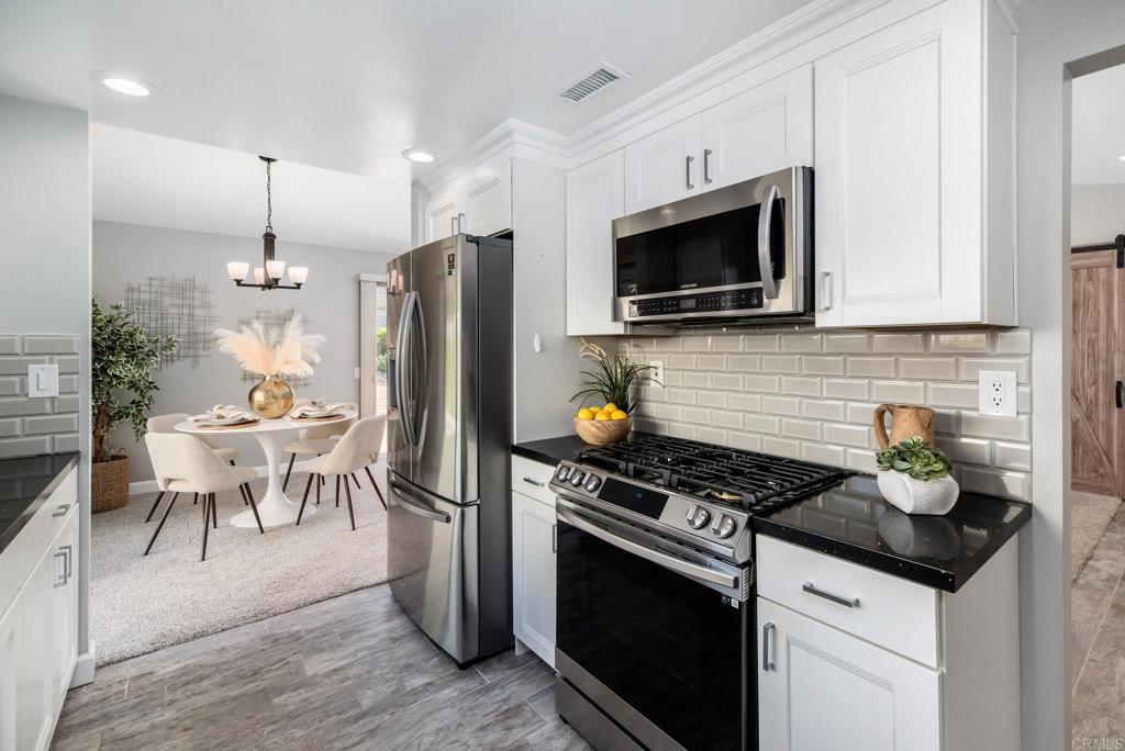 2725 Glasgow Drive Carlsbad, CA 92010 - Photo 14 of 41 a kitchen with stainless steel appliances kitchen island granite countertop a stove and a microwave
