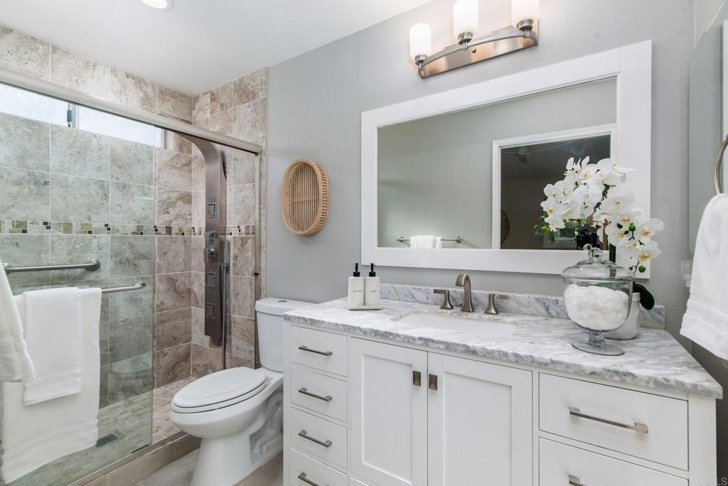 2725 Glasgow Drive Carlsbad, CA 92010 - Photo 20 of 41 a bathroom with a granite countertop sink a toilet and a mirror