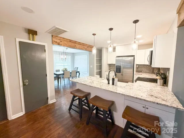 a kitchen with a table chairs refrigerator and cabinets
