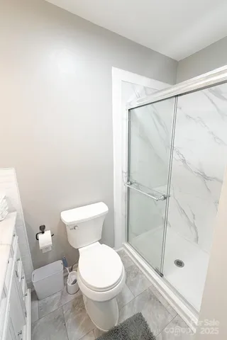 a white toilet sitting next to a shower