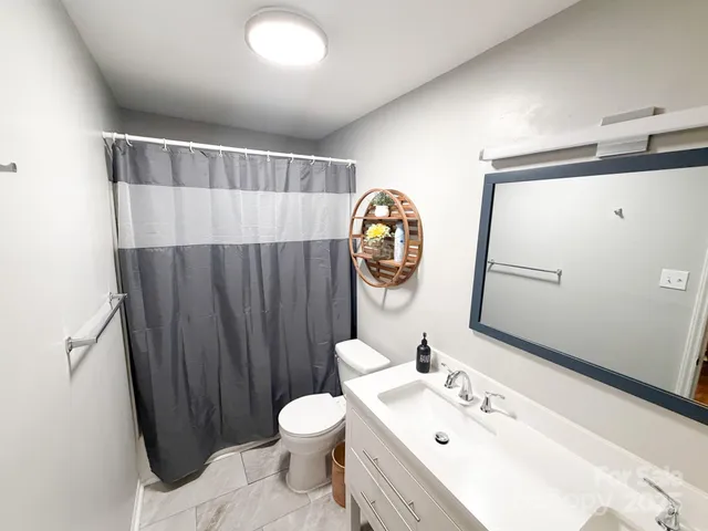 a bathroom with a sink mirror vanity and toilet