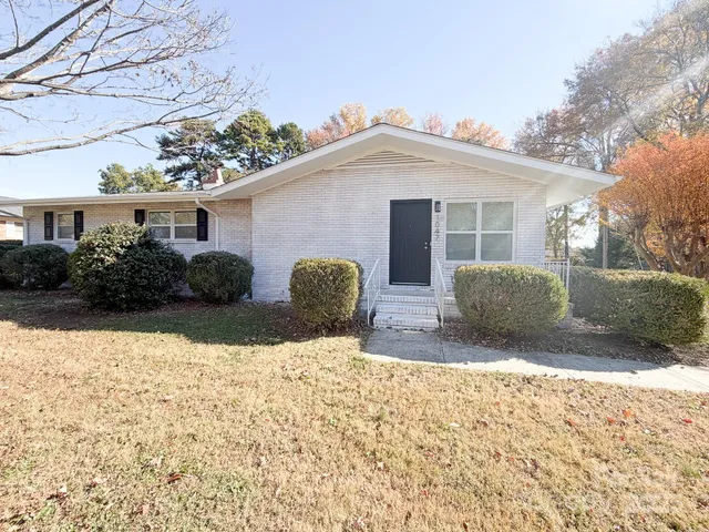 a view of a house with yard and a large tree