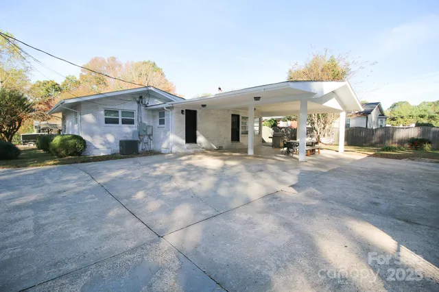 a view of a house with a small yard and large tree