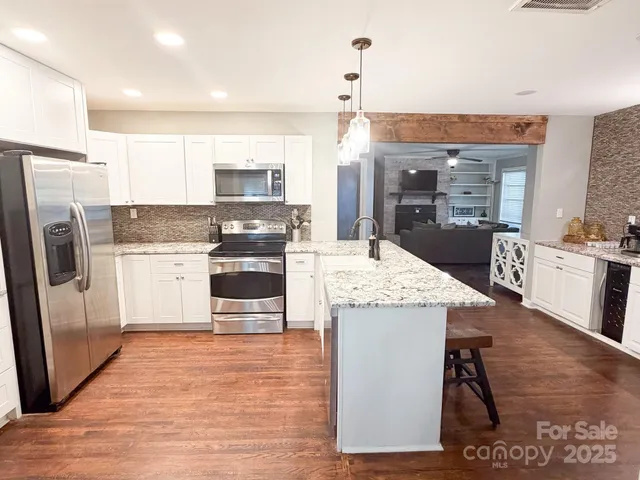 a kitchen with stainless steel appliances kitchen island granite countertop a stove and a refrigerator