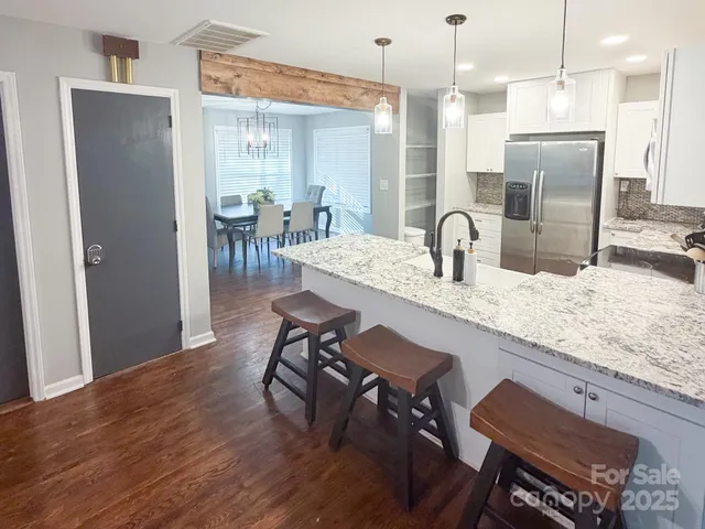 a kitchen with granite countertop kitchen island microwave and refrigerator