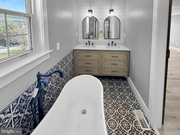 a bathroom with a sink a mirror and a bathtub