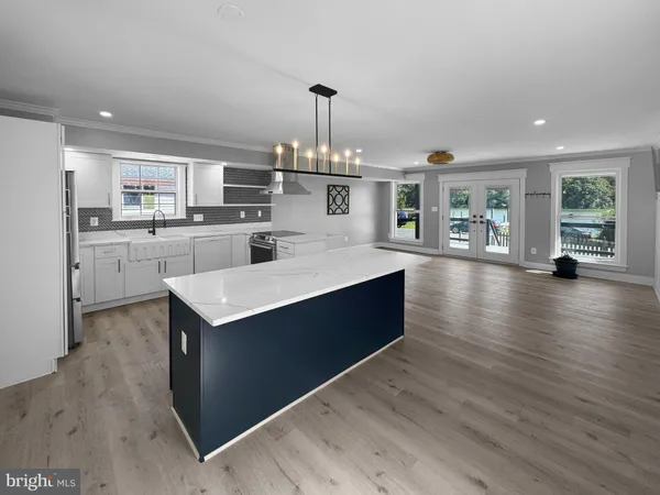 a kitchen with stainless steel appliances granite countertop a sink dishwasher stove and refrigerator with wooden floor