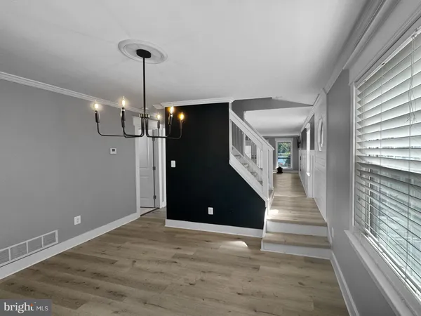 a view of a livingroom with wooden floor and stairs