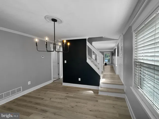 a view of a livingroom with wooden floor and stairs