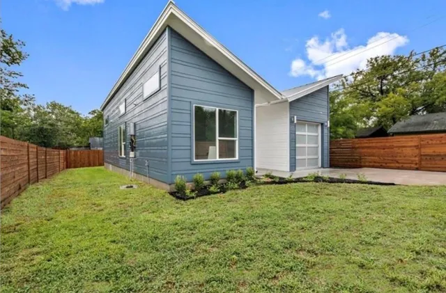 a view of backyard of house with green space