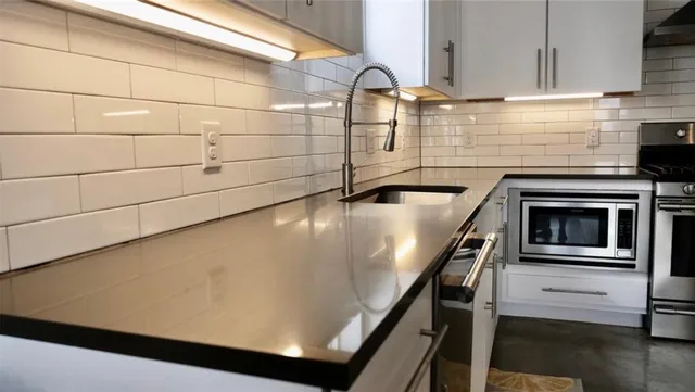 a close view of a stove kitchen counter space and cabinets