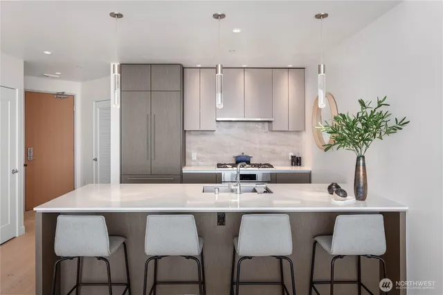 a kitchen with granite countertop a sink and white cabinets