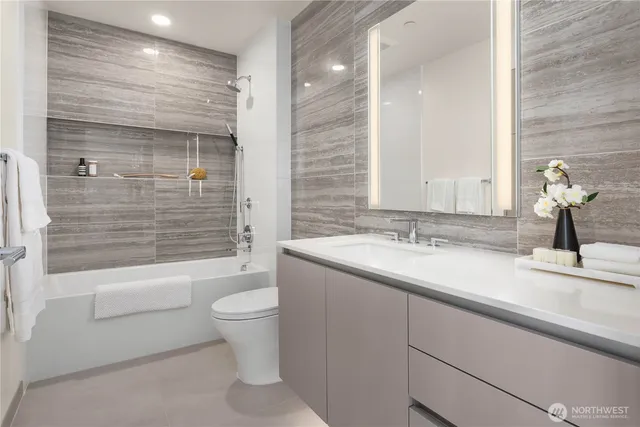a bathroom with a granite countertop sink toilet and shower