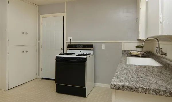 a kitchen with a refrigerator and a stove top oven