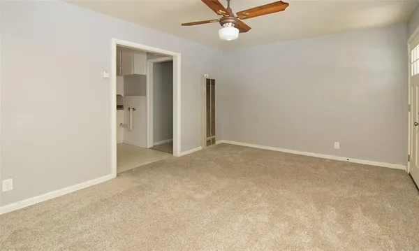 an empty room with a ceiling fan and a window