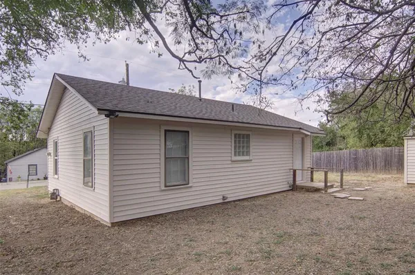 a view of a house with a yard and wooden fence