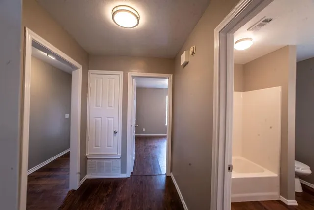 a view of a hallway with wooden floor