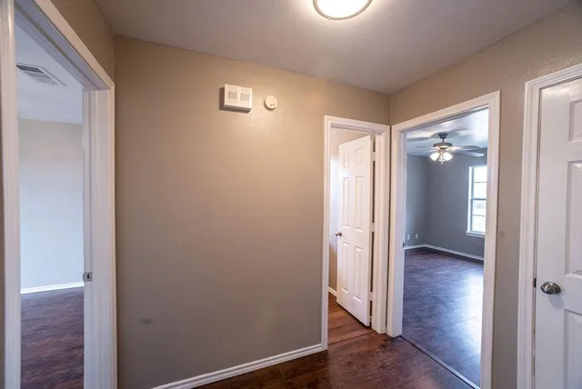 an empty room with wooden floor and a bathroom